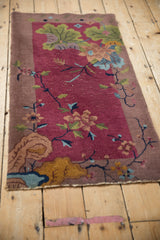 Art Deco pictorial rug detail: burgundy lotus, green leaves, and visible knot heads.