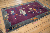 Antique Art Deco rug's corner with deep violet field, slate blue border, and tattered machine-bound end.