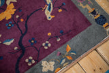 Angled view of deep violet field, slate gray border with tangerine leaves, and machine-bound end.
