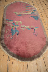 Antique Art Deco pictorial rug detail: dusty blush field, blue-green trees, worn beige edge.