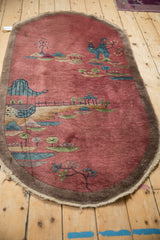 Antique Chinese Art Deco rug corner detail with tattered edge, brown border, dusty blush.
