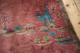 Faded cochineal red field, brown edge, blue-green pictorial landscape motifs, with streaks.