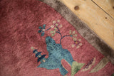 Antique Chinese Art Deco rug detail: blue pagoda, blossoming branches on faded cochineal red.