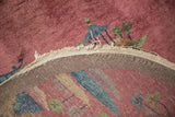 Tattered edge of a dusty blush Art Deco runner, revealing its hand-knotted reverse weave.