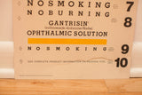 Vintage eye chart with large bottom rip, 1964 copyright, and lines 9-10.