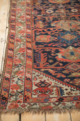 Antique Malayer runner's geometric border, tattered fringe, and worn cobalt field patterns.