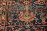 Worn geometric palmette motifs in dark blue, peach, and brown on an antique Malayer rug.