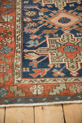 Vintage Karaja rug corner with madder root red serrated leaf border and visible selvage.