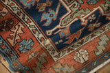 Close-up of hand-knotted Karaja rug's rolled edge, with cobalt blue, madder red geometric motifs.