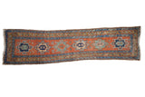 Antique Northwest Persian runner with a central column of geometric medallions in red, blue, and gold hues.