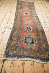 An angled, full-length view of the antique Persian runner's geometric medallion column.