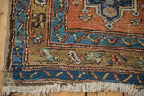 Secured end of an antique rug showing the hand-knotted pile, foundation, and short fringe.