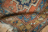 Detailed texture of a folded antique Persian runner, showing visible knot heads and color abrash.