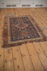 Vintage Karaja rug's geometric diamond medallion and varied navy, rust, teal patterns.