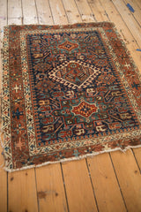 Vintage Karaja rug corner with geometric pawn design, tattered fringe, and navy, rust tones.