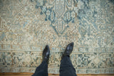 Distressed Mehrivan carpet pile with geometric ivory, blue, and brown patterns.