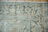 Distressed hand-knotted Mehrivan rug corner, showing ivory, beige, blue geometric patterns, even wear.