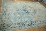 Corner detail of distressed Mehrivan carpet, showing ivory, blue, and brown patterns with even wear.