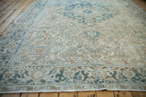Faded blue, beige, and brown geometric patterns; even wear on a distressed vintage Mehrivan carpet.
