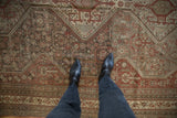 Distressed vintage Shiraz carpet with geometric floral motifs in chestnut and time-softened silver.