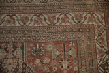 Distressed Shiraz rug corner with geometric borders and field in chestnut brown, antique ivory.
