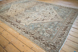 Distressed vintage Kamseh carpet corner, tribal brown geometric border, and machine-bound side.