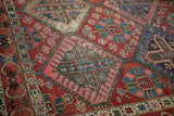Bakhtiari carpet detail with red lattice, sapphire blue florals, crab border, and foundation wear.