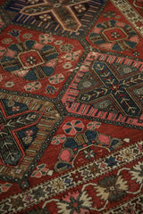 Vintage Bakhtiari carpet close-up, showing lattice panels with multi-colored floral petals and crab border.
