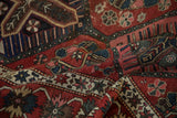 Folded Bakhtiari carpet in ruby red, sapphire blue with lattice and floral fills.
