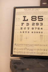 Antique eye exam plaque with black near vision charts and J.E.L. 1935 musical score.