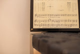 Antique eye exam plaque displaying musical notation and 1935 distribution text.