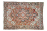 Vintage distressed Heriz carpet with concentric floral medallion in time-softened rust, slate blue, and charcoal.