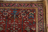 Faded magenta border and unique camel-hued stripe on a Persian Lilihan rug corner.