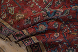 Antique Persian Lilihan rug with cherry red field, intricate palmettes, and faded magenta camel hair border detail.