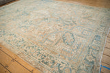 Distressed vintage Heriz rug edge revealing faded cream, powder blue geometric patterns.