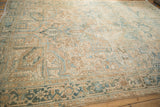 Distressed vintage Heriz carpet highlighting geometric patterns in cream, faded sapphire, and sand.