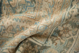 Distressed vintage Heriz carpet folded, revealing low pile and geometric motifs in cream and powder blue.