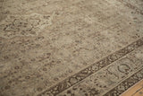 Distressed vintage Bijar carpet detail: worn beige field, chocolate Herati pattern, faded blue border.