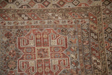 Vintage Kamseh carpet with intricate geometric patterns, banded borders, and madder root rust tones.