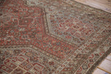 Detail of vintage Persian Kamseh carpet with madder root rust, silver geometric motifs, and even wear.
