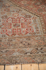 Persian Kamseh carpet's geometric pattern in madder root rust, dark brown, and silver with even pile wear.