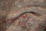 Distressed Tabriz rug shows cherry red, slate blue Herati motif with faint foundation wear.