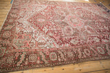 Vintage Heriz border detail with geometric motifs, softened red, beige, and bronze patina.