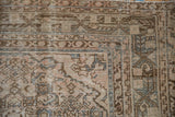 Vintage Distressed Hamadan carpet corner, showing worn pile, geometric border, and soft beige and blue patterns.