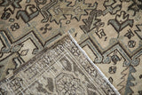 Distressed vintage Heriz rug pile showing wear, revealing foundation weave in beige and dusty teal.