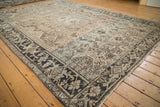 Distressed vintage Heriz carpet showing geometric floral designs and turtle border with worn, muted tones.