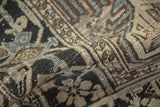 Distressed Heriz carpet close-up, showcasing worn pile, geometric patterns, and slate blue abrash.