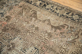 Distressed vintage Heriz carpet showing heavy abrashes, geometric motifs, and faint foundation.