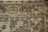 Distressed Mehrivan rug section, geometric patterns, visible knot heads, textured pile in beige and brown.