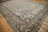 Distressed Mehrivan carpet edge showing geometric motifs in muted beige, charcoal, and softened texture.